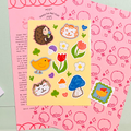 Sticker sheet with cartoon animals and objects on a pink background, with a decorative mirror in the background.