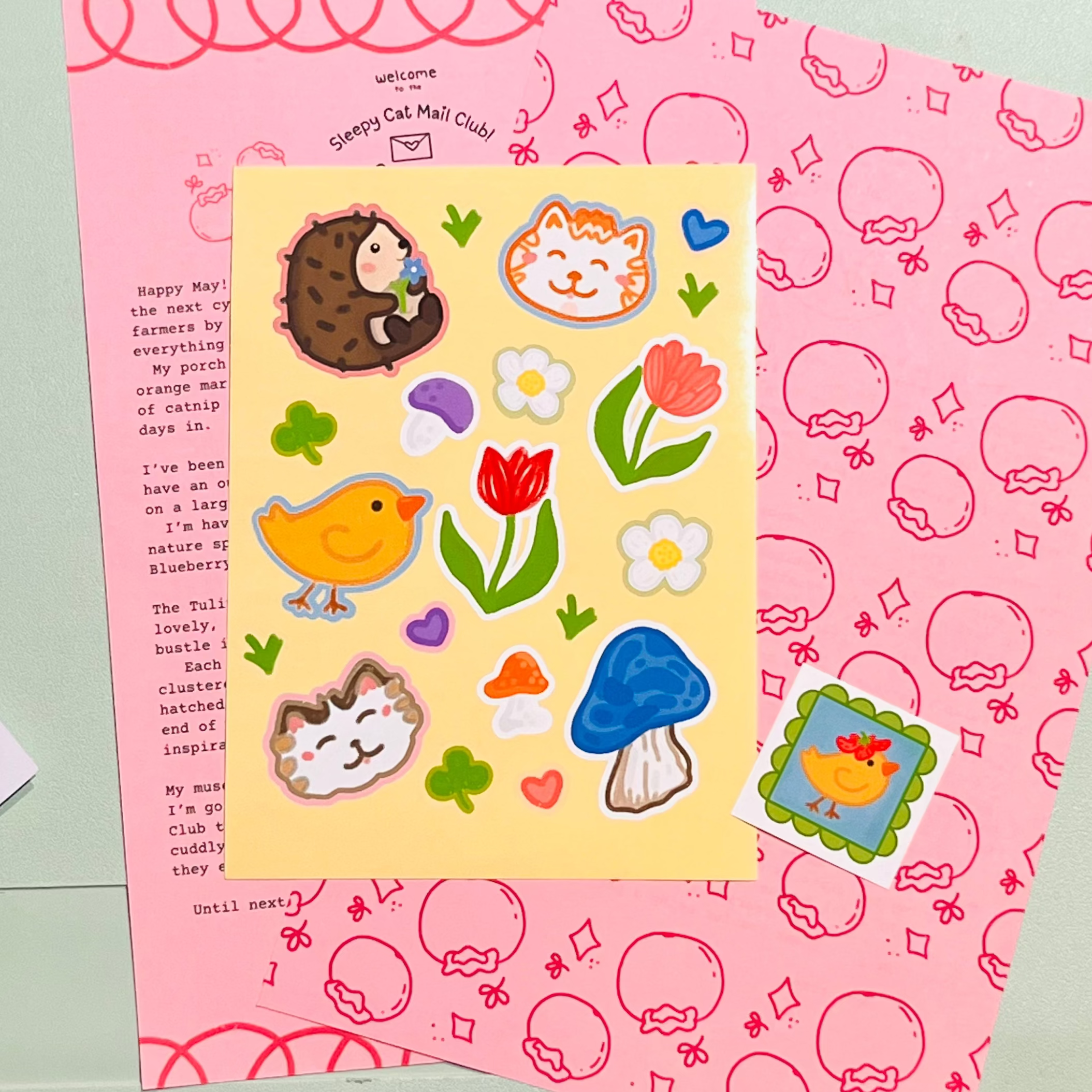 Sticker sheet with cartoon animals and objects on a pink background, with a decorative mirror in the background.
